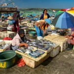 Dasar-Dasar yang Perlu Kamu Tahu tentang Ekonomi Mikro dalam satuHal! Feature image aktivitas pedagangan di pasar ikan